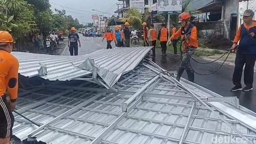 BPBD Klungkung mengevakuasi atap rumah warga yang diterbangkan angin puting beliung di Jalan Raya Gunaksa, Kecamatan Dawan, Klungkung, Selasa 10/12/2024). (Foto: Putu Krista/detikBali)