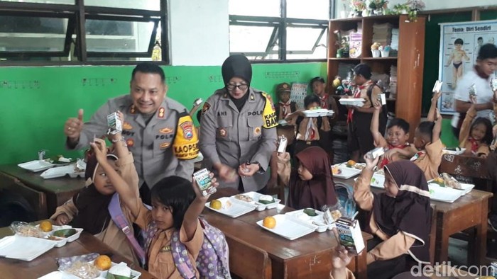 Kapolres Pasuruan AKBP Teddy Chandra membagikan makan bergizi gratis ke siswa SD