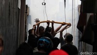Warga juga turut menarik selang-selang air dari mobil petugas damkar.  
