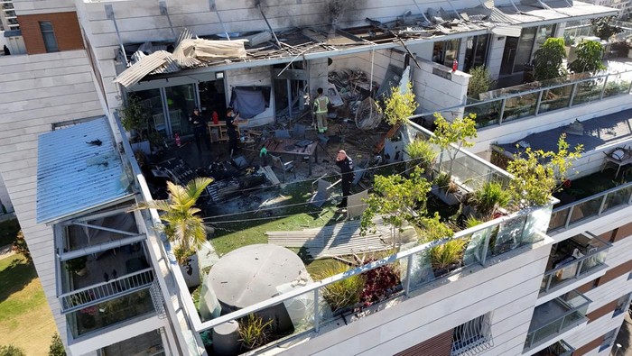 A man stands next to broken glass at the scene of a residential building which Israel's military said had been hit by a UAV that was likely fired from Yemen, in Yavne, Israel, December 9, 2024. REUTERS/Stoyan Nenov