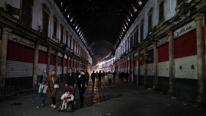 Kondisi Damaskus Saat Jam Malam Diberlakukan People walk at Al-Hamidiyah Souq, after rebels seized the capital and ousted Syria's Bashar al-Assad, in Damascus, Syria December 9, 2024. REUTERS/Mohamed Azakir