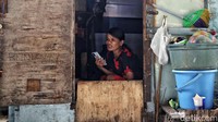 Seorang warga beraktivitas di rumah semipermanen yang dibangun di kolong Tol Gedong Panjang, Jakarta Utara.