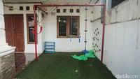 Garis polisi berwarna kuning dipasang melintang di depan pagar.
