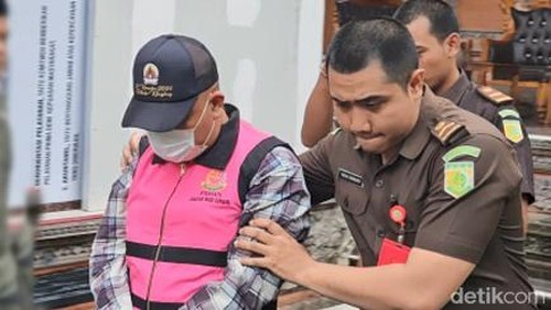 Perbekel Dawan Kaler saat dikeler petugas menuju mobil tahanan, Senin (9/12/2024). (Putu Krista/detikBali).