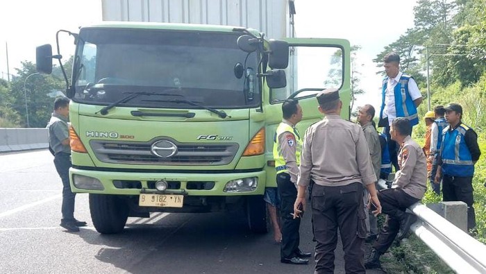 Polisi di lokasi sopir truk tewas menggantung di pintu kendaraannya, di Tol Solo-Semarang KM 428.600 jalur B, Selasa (10/12/2024).
