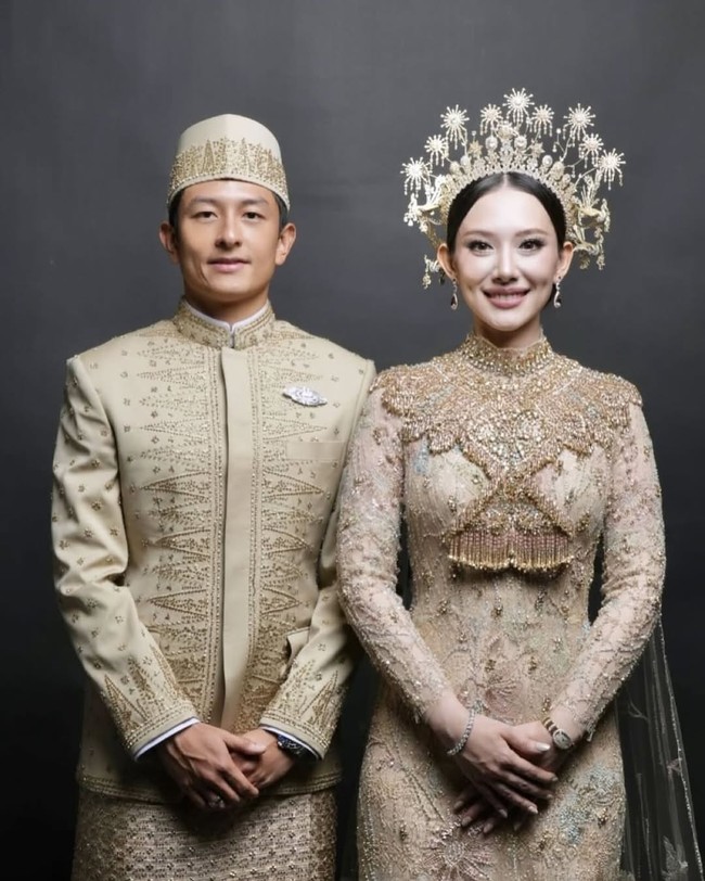 Istri Rio Haryanto, Athina, tampil anggun dan cantik berbalut gaun bersiluet kebaya warna emas rancangan Biyan Wanaatmadja.  Foto: Instagram/@leonardiwedding @itsfrankywu