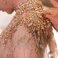 Gaun lace sarat akan detail dengan penekanan pada bagian leher dan dada yang dipenuhi rangkaian payet, kristal serta sequin. Aksen cape panjang menerawang menambah kesan dramatis. Foto: Instagram/@leonardiwedding @itsfrankywu