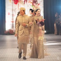 Rio Haryanto tak kalah tampil menawan. Pria 31 tahun ini mengenakan setelan beskap bernuansa emas. Aksen kain tentun dengan benang emas memperkuat sisi tradisional adat Betawi. Foto: Instagram/@leonardiwedding @itsfrankywu