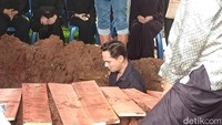 Andhika Pratama turun ke liang lahad untuk menguburkan mertuanya. Foto: Ahsan/detikhot