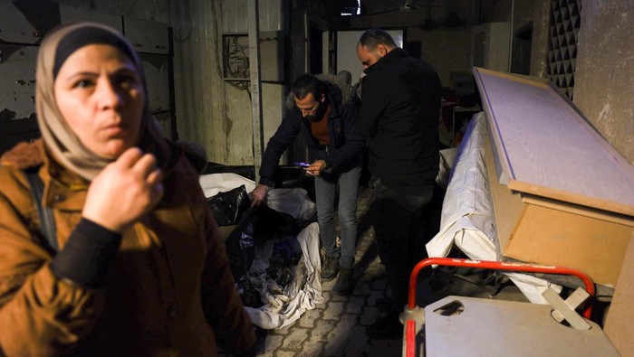 People transport a body, believed to be of a prisoner from Sednaya prison, according to forensic official Zaher al-Taqesh, near the Al Mojtahed hospital, after rebels seized the capital and ousted Syria's Bashar al-Assad, in Damascus, Syria December 10, 2024. REUTERS/Mohamed Azakir