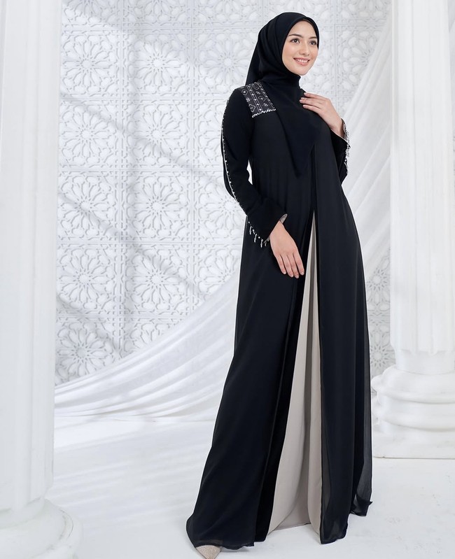 Memakai dress hitam potongan layer dengan detail print brand dan beads pada bagian bahu, Citra Kirana tampil anggun dengan hijab segi empat yang dibentuk rapi.  Foto: Dok. Instagram @citraciki.