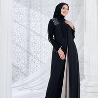Memakai dress hitam potongan layer dengan detail print brand dan beads pada bagian bahu, Citra Kirana tampil anggun dengan hijab segi empat yang dibentuk rapi.  Foto: Dok. Instagram @citraciki.