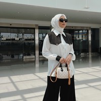 Ketika sedang di lokasi syuting, wanita yang akrab disapa Ciki ini tampil chic dengan kemeja putih aksen motif garis bagian bahu. Dipadukan dengan palazzo pants hitam. Foto: Dok. Instagram @citraciki.