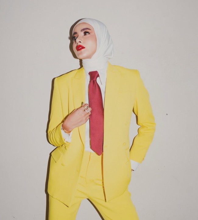 Wanita kelahiran 15 Februari 1980 ini membentuk rapi hijab pashmina yang diikat ke belakang. Ia juga menambahkan dasi warna merah sebagai aksesori. Foto: Dok. Instagram @ollaramlan.