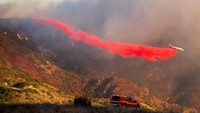 Sebuah pesawat pemadam kebakaran menjatuhkan retardant untuk memperlambat penyebaran Franklin Fire di kawasan yang sulit dijangkau. Foto: REUTERS/Ringo Chiu