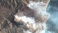 Asap tebal mengepul di atas pemukiman di Malibu, menunjukkan skala kebakaran yang terus meluas. Hembusan angin hingga 129 km/jam semakin mempersulit upaya pemadaman. Foto: via REUTERS/Maxar Technologies