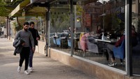 Warga berjalan di depan sebuah kafe di Aleppo. 