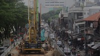 Para pengendara melintas di samping proyek infrastruktur Light Rail Transit (LRT) Velodrome-Manggarai, di Pasar Rumput, Jl Sultan Agung, Jakarta Selatan, Kamis (12/112/2024).
