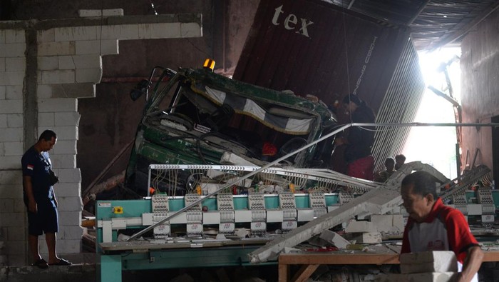 Warga berada di dekat truk kontainer yang mengalami kecelakaan tunggal menabrak bangunan di Jalan Solo-Semarang, Boyolali, Jawa Tengah, Kamis (12/12/2024). Kecelakaan tunggal truk kontainer bermuatan biji plastik itu menabrak bangunan gudang yang diduga truk mengalami masalah pada pengereman dan dalam peristiwa tersebut tidak ada korban jiwa. Antara Foto/Aloysius Jarot Nugroho