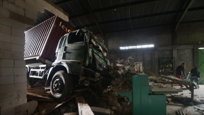 Warga berada di dekat truk kontainer yang mengalami kecelakaan tunggal menabrak bangunan di Jalan Solo-Semarang, Boyolali, Jawa Tengah, Kamis (12/12/2024). Kecelakaan tunggal truk kontainer bermuatan biji plastik itu menabrak bangunan gudang yang diduga truk mengalami masalah pada pengereman dan dalam peristiwa tersebut tidak ada korban jiwa. Antara Foto/Aloysius Jarot Nugroho