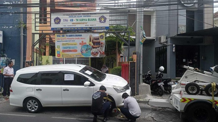 Dishub Kota Malang menderek mobil Nissan Livina di Jalan Joyo Tambaksari, Kecamatan Lowokwaru
