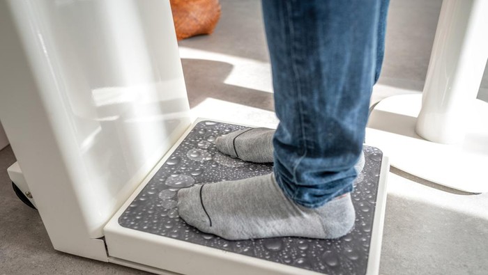 Male on weight scale on floor background, Diet concept.