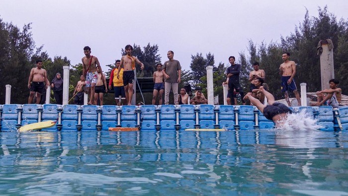Melihat latihan para penjaga pantai Peserta membawa papan penyelamat (surf rescue board) untuk menyelamatkan wisatawan yang tercebur saat ujian terakhir hasil latihan penjaga pantai (lifeguard) di Pulau Tidung, Jakarta.
