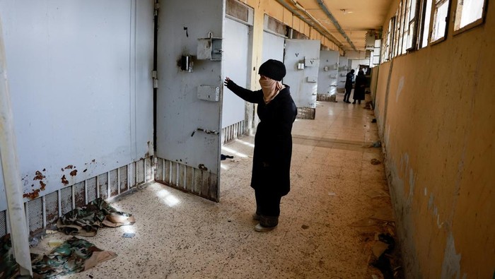 Hayat al-Turki, 27, holds a gallow inside Sednaya prison, which was known as a slaughterhouse under Syria's Bashar al-Assad rule, as she searches the prison in the hope of finding her relatives, after rebels seized the capital and announced that they have ousted Syria's Bashar al-Assad, in Sednaya, Syria, December 11, 2024. REUTERS/Ammar Awad