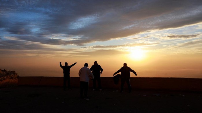 People look at the sun rising over Damascus days after rebels seized the capital and ousted President Bashar al-Assad in Damascus, Syria, December 12, 2024. REUTERS/Ammar Awad