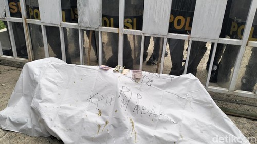 Pengunjuk rasa membawa tanah kuburan dan keranda mayat saat berunjuk rasa di depan KPU Manggarai Barat, Kamis (12/12/2024).