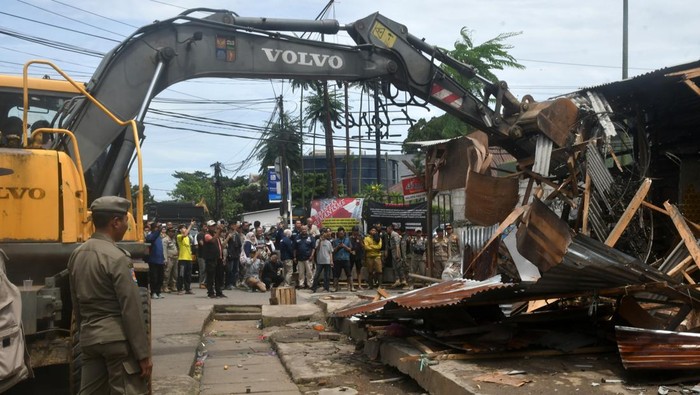 Petugas SAtpol PP Bongkar Paksa Puluhan Kios Pedagang di Kota Bogor Sebuah alat berat bersiap melakukan pembongkaran kios di jalan Merdeka, Kota Bogor, Jawa Barat, Kamis (12/12/2024). Sebanyak 43 kios semi permanen dipinggir jalan tersebut dibongkar petugas Satpol PP Kota Bogor karena tidak memiliki izin usaha atau ilegal dan menjadi sumber kemacetan dan kekumuhan. Antara Foto/Arif Firmansyah