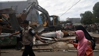 Warga melintas saat pembongkaran kios pedagang di jalan Merdeka, Kota Bogor, Jawa Barat, Kamis (12/12/2024).
