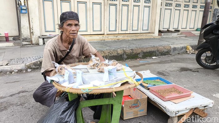Suma di depan lapak pakan burungnya