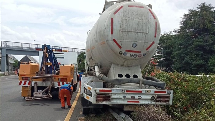 Truk kecelakaan hingga tersangkut pembatas jalan di Tol Cililitan arah Jagorawi.