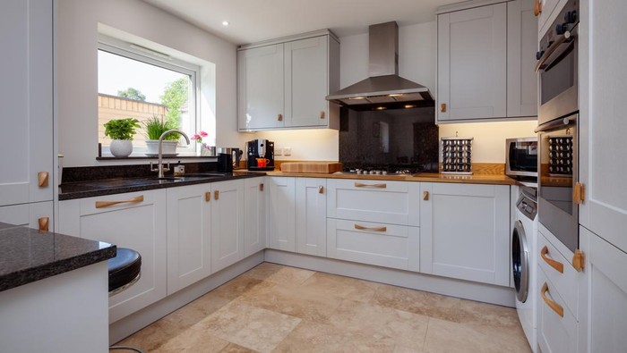 Modern contemporary shaker style fitted kitchen with built in appliances breakfast bar and granite counbter tops