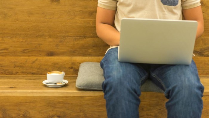 Using laptop and having coffee while working at home