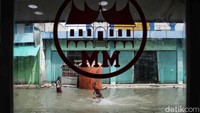 Anak-anak menjadikan banjir rob sebagai arena bermain.
