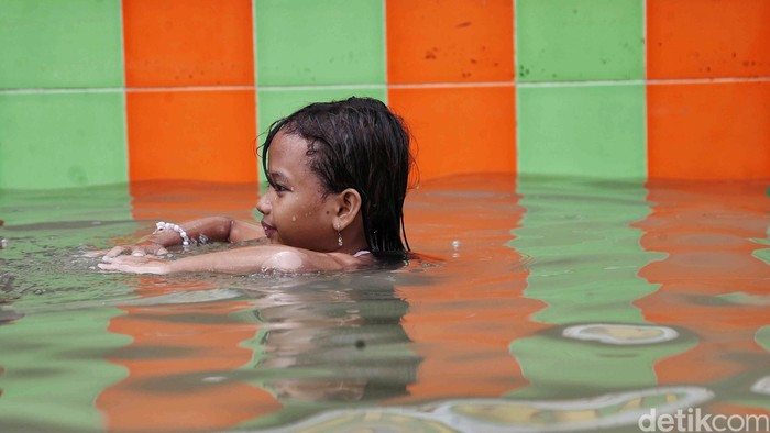 Sejumlah warga beraktivitas saat banjir rob kawasan Muara Angke, Jakarta Utara, Jumat (13/12/2024). Banjir rob sejak pagi itu kembali merendam permukiman dengan ketinggian air 30 - 50 cm.