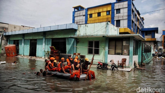 Sejumlah warga beraktivitas saat banjir rob kawasan Muara Angke, Jakarta Utara, Jumat (13/12/2024). Banjir rob sejak pagi itu kembali merendam permukiman dengan ketinggian air 30 - 50 cm.