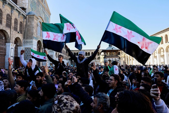 People wave the flag adopted by the new Syrian rulers at Umayyad Mosque on the first Friday after members of the ruling Syrian body settle in to take control of the city, after Syrias Bashar al-Assad was ousted by fighters of the ruling Syrian body, in the Damascus old city, Syria December 13, 2024. REUTERS/Ammar Awad