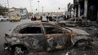 Orang-orang berjalan di dekat kendaraan yang terbakar setelah kebakaran di Departemen Imigrasi dan Paspor yang dikelola oleh Kementerian Dalam Negeri Suriah, setelah pemberontak merebut ibu kota dan menggulingkan Bashar al-Assad. REUTERS/Amr Abdallah Dalsh