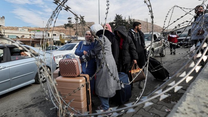 Bingkai Sepekan: Tumbangnya Rezim Assad People stand near razor wire at Masnaa Border Crossing, after Syrian rebels announced that they have ousted President Bashar al-Assad, Lebanon, December 8, 2024. REUTERS/Amr Abdallah Dalsh