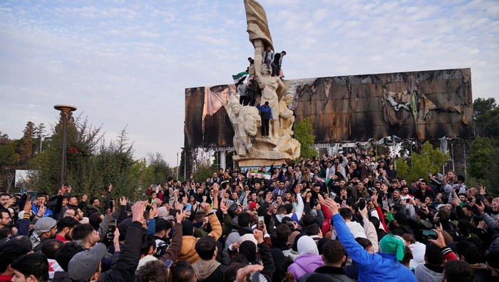 People gather at Saadallah al-Jabiri Square as they celebrate, after Syrias army command notified officers on Sunday that President Bashar al-Assads 24-year authoritarian rule has ended, a Syrian officer who was informed of the move told Reuters, following a rapid rebel offensive that took the world by surprise, in Aleppo, Syria December 8, 2024. REUTERS/Karam al-Masri