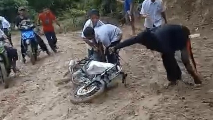Jalanan rusak dan licin di Pinrang membuat siswa terjatuh dari motornya.