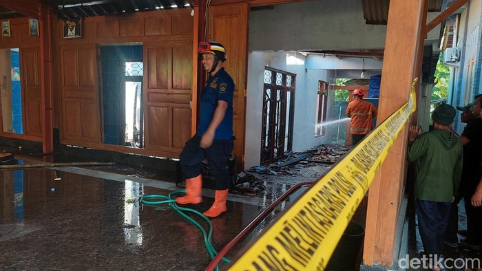 Tim damkar Kulon Progo saat melakukan pendinginan rumah terbakar di Temon, Kulon Progo, Jumat (13/12/2024).