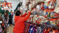 Seorang pembeli sedang memilih pernak-pernik untuk hiasan natal.