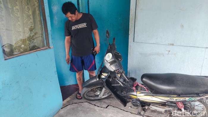 Warga menunjukkan retakan di rumahnya dampak pergerakan tanah