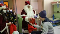 Pria yang mengenakan kostum Sinterklas, letnan dua pemadam kebakaran Eleftherios Dimitrakopoulos, ditemani oleh Nyonya Sinterklas dan para pembantu mereka, mengunjungi pasien di kamar mereka, mengobrol dengan mereka, dan memberi mereka hadiah. 