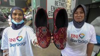Pekerja menunjukan sepatu yang dibuat dari limbah pakaian bekas. Aksi ramah lingkungan ini untuk membantu mengurangi limbah serta mendorong ekonomi sirkular yang berkelanjutan.