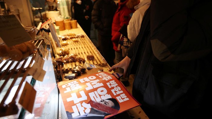 Protestors taking part in a rally calling for the impeachment of South Korean President Yoon Suk Yeol, who declared martial law, which was reversed hours later, rest at a cafe that offers free drinks and shelter against cold weather in front of the National Assembly in Seoul, South Korea, December 14, 2024. REUTERS/Kim Hong-Ji